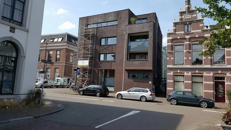 Appartementengebouw van een VvE in Utrecht met een rolsteiger tegen de gevel tijdens het buitenschilderwerk.